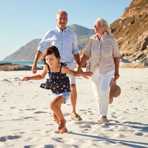 Elderly couple and granddaughter happily making beach memories - Law Office Of Jeffrey W. Johnson